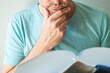 Closeup of male reading book and stroking chin
