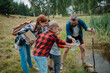 © Halfpoint - Teacher showing lake water to school children, during field teaching class. Outdoor active education helping young student to learn about ecosystem.