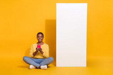 Wall Mural - Portrait of attractive cheerful girl using device copy space new offer ad advert isolated on bright yellow color background