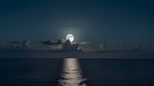 This Large Full Blue Moon Rises Brightly Over The Cloud Bank In This Calm Ocean, Moonlight Over The Sea.generative.ai 