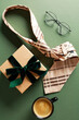 Flatlay composition with tie, gift box, coffee cup, glasses on dark green background. Happy Fathers Day concept.