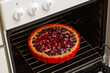 Closeup homemade berry pie baked in a home oven.