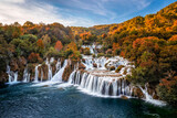 Fototapeta Big Ben - Krka, Croatia - Aerial view of the beautiful Krka Waterfalls in Krka National Park on a sunny autumn morning with colorful autumn foliage and blue sky at sunrise