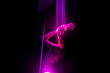 Beautiful woman dancing under pink illumination, laser light, neon party night club. Projection mapping. Interactive exposition installation.