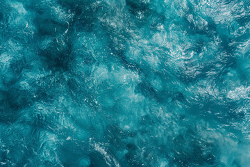 Aerial view of a turquoise water surface texture in a flat lay shot from a top down perspective in a close up