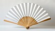 A close shot of a folding traditional white fan mockup for summer kept on a studio white background with space for text or product, Generative AI.