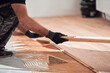 Professional handyman installing laminate flooring in a new apartment.