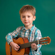 Portrait of little boy learning to play classic guitar