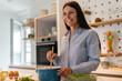 Portrait of a woman in the kitchen of her home for health diet or nutrition. Smile, food and cooking