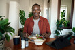 Smiling young African man eating a home cooked breakfast