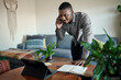 African businessman working from home using his phone and tablet