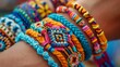 A close up of a person's arm wearing a lot of colorful woven friendship bracelets.