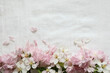 Spring flower arrangement Festive frame border of white apple tree flowers, pink sakura cherry tree blossoms on blurred white linen tablecloth background. Web banner, design element for postcard