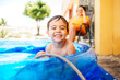 © kleberpicui - Happy child playing in inflatable home pool in summer. Active outdoor recreation.