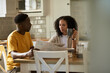 Young multiethnic couple reading a newspaper during breakfast at home