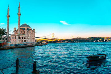 Wall Mural - A mosque with a blue sky in the background. Ortakoy Mosque, Besiktas Turkey. A mosque in Istanbul with the bridge in the background.