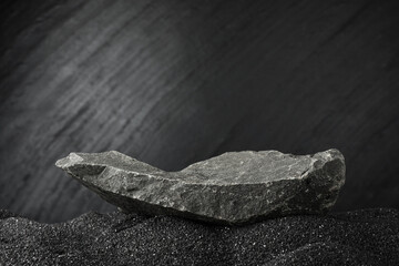 Wall Mural - Presentation of product. Stone podium on black sand against dark textured background. Space for text