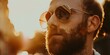 Close-up of a bearded man wearing sunglasses during a golden hour sunset.