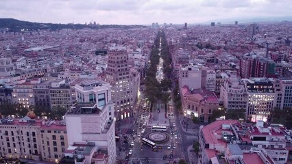 Wall Mural - Barcelona at dusk with city lights starting to glow, traffic on streets, aerial view