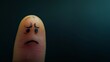 Close-up of a sad face drawn on a fingertip