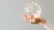A hand gently holding a translucent sphere with a glowing digital network, symbolizing connectivity and technology.