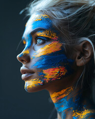 Wall Mural - A fashion photography of ukrainian woman with a smeared ukrainian flag pattern on her face, matte skin, minimalist, soft and back light, dark background, expressionism, soft shadows