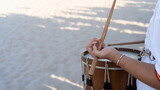 Fototapeta Na drzwi - Close-up of a girl's hands playing a percussion musical instrument with sticks, a drum outdoors