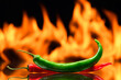 red and green chili peppers, on a background of burning fire, flames on a black background, hot and spicy spices