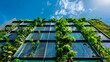 © yaqui_villegas - An eco-conscious building facade adorned with solar panels and green plants against a bright blue sky