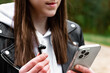 Young woman listening to music using headphones and a smartphone.