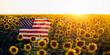 Beautiful young woman with the American flag in a sunflower field at sunset. 4th of July. Independence Day.	