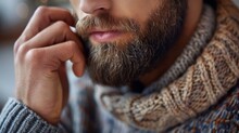   A Man With A Beard Wears A Scarf Around His Neck And Another One Over His Head, Revealing Only His Eyes He Holds A Cell Phone To His Ear