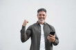 © Stock 4 You - Happy delighted satisfied business man looking smartphone mobile phone gesturing yes winning pose, isolated background. Overjoyed excited businessman, doing winner gesture, reading good news. Vertical