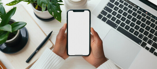 Business person man or woman holding smartphone showing mock up blank white empty mobile phone screen, hands using cellphone close up view. Mockup display for applications ads.