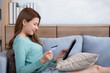 Young asian woman sitting on sofa using digital tablet shopping online with credit card buying to internet, female payment with business on couch, purchase and payment, business and lifestyles.