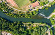 Strasbourg, France. Football field and garden plots. Riffle with a dam on the Ill River. Panorama on a summer day. Sunny weather. Aerial view