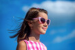 Happy little girl with sunglasses looking at the sun. Children with sunglasses looking at the sky with sun in summer. Cute girl, smile, happy in sky background, young kid and retro clothes, glasses