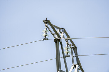 High voltage metal tower with glass insulators supporting the cables