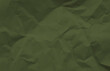 close up view of dark green crumpled piece of construction paper use as background with blank space for design. soldier color concept.