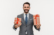 Happy rich businessman in suit holding present boxes isolated over white background. Successful manager banker giving receiving gifts for holiday occasions special events concept