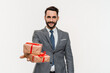Rich young businessman giving presents to camera isolated over white background. Receiving gifts - love language concept. Surprise for special occasions holidays
