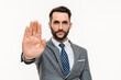 Serious young businessman showing stop gesture with the palm isolated over white background. Angry Caucasian manager forbid ban pushing protects interrupt
