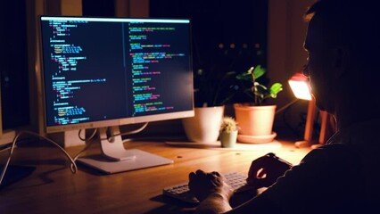 Wall Mural - a young man programmer coding on a laptop in the dark with a view of the lights of the night city, c