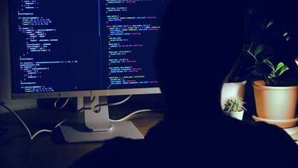 Wall Mural - a young man programmer coding on a laptop in the dark with a view of the lights of the night city, c