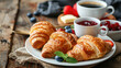 Continental breakfast with croissants, jam, butter, fresh fruit, and coffee, Rustic background.