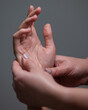 The masseuse massages the client's palms. Close-up of hands at a spa treatment. Vertical photo. 