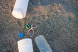 A bottle cap and a plastic bottle are on the beach