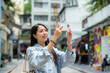 Tourist woman use mobile phone to take phone in city