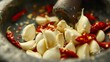 A close-up of garlic cloves and chili peppers being pounded together in a mortar and pestle, a key step in preparing Thai curry paste