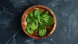 Wooden round plate with fresh spinach leaves top